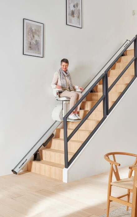 lady going up stairway on a stair lift