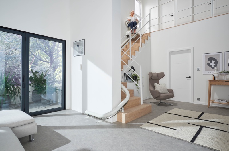 flow x curve stair lift with woman near top of stairs