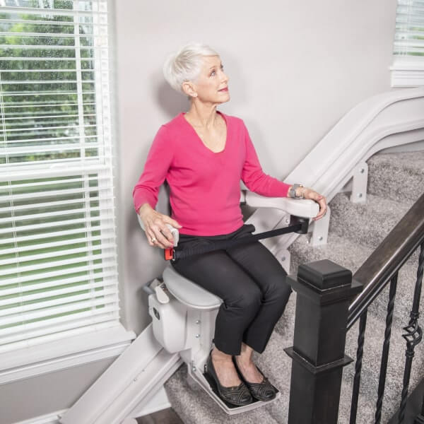 woman on of stairs using curved stair lift