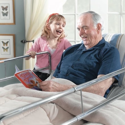 Grandpa reading a book to granchild while in bed