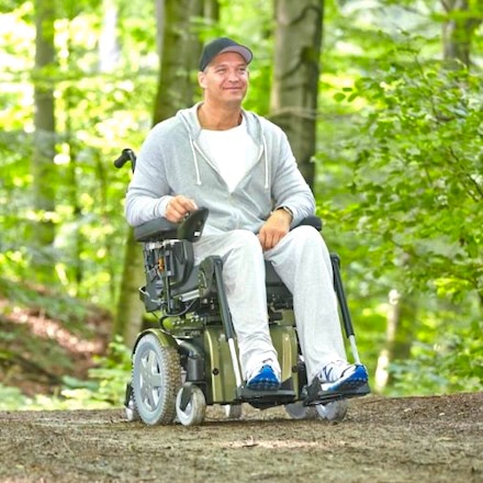 Man riding power wheelchair in park