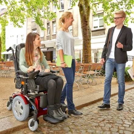 student on wheelchair  with friends