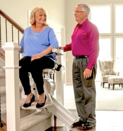 wife rides stairlift up stairs
